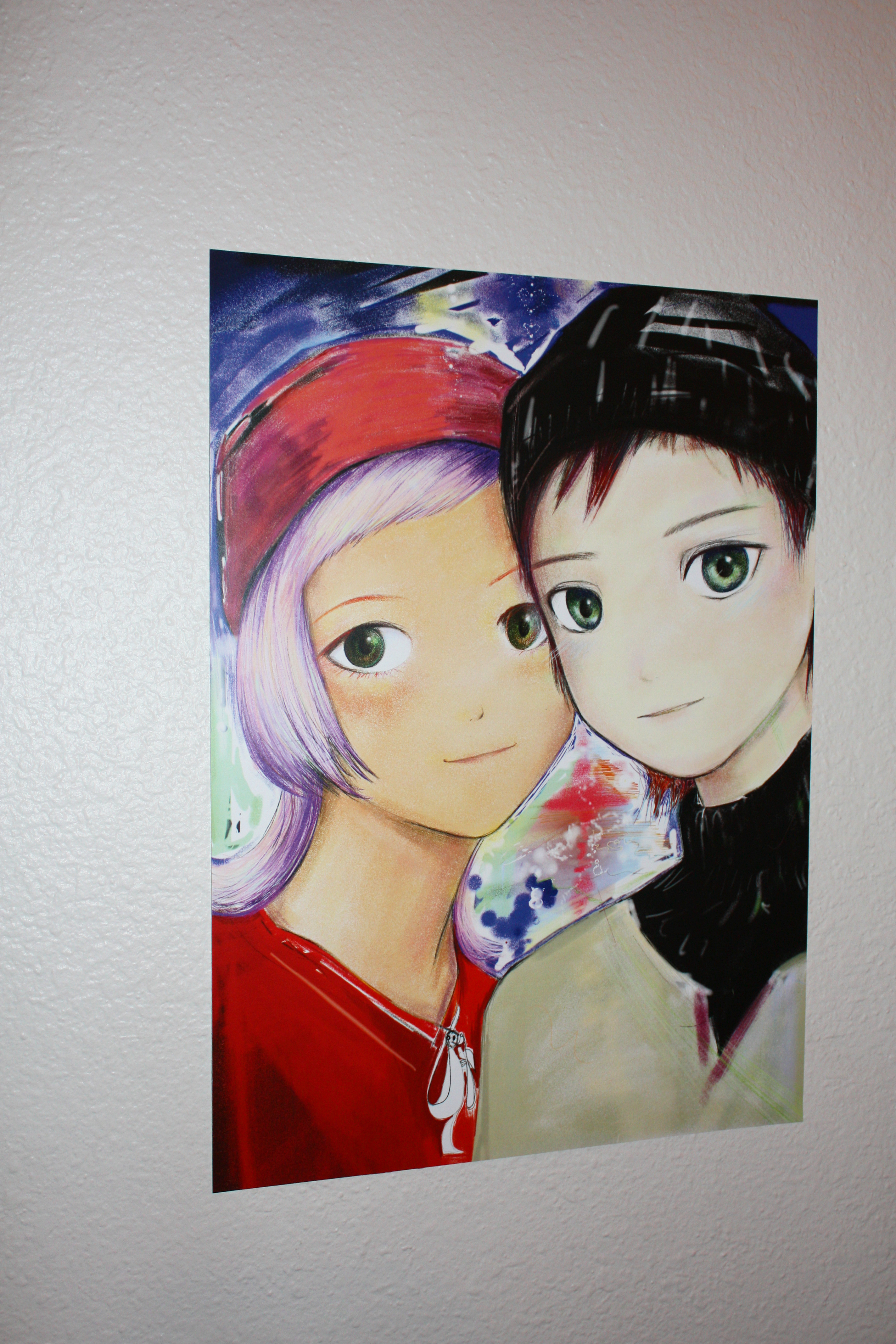 Detail of an anime boy and girl smiling hung on a white wall